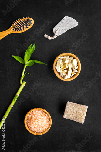 Asian spa background. Spa treatment concept. Bamboo branch  spa cosmetics on black background top view. Foot spa