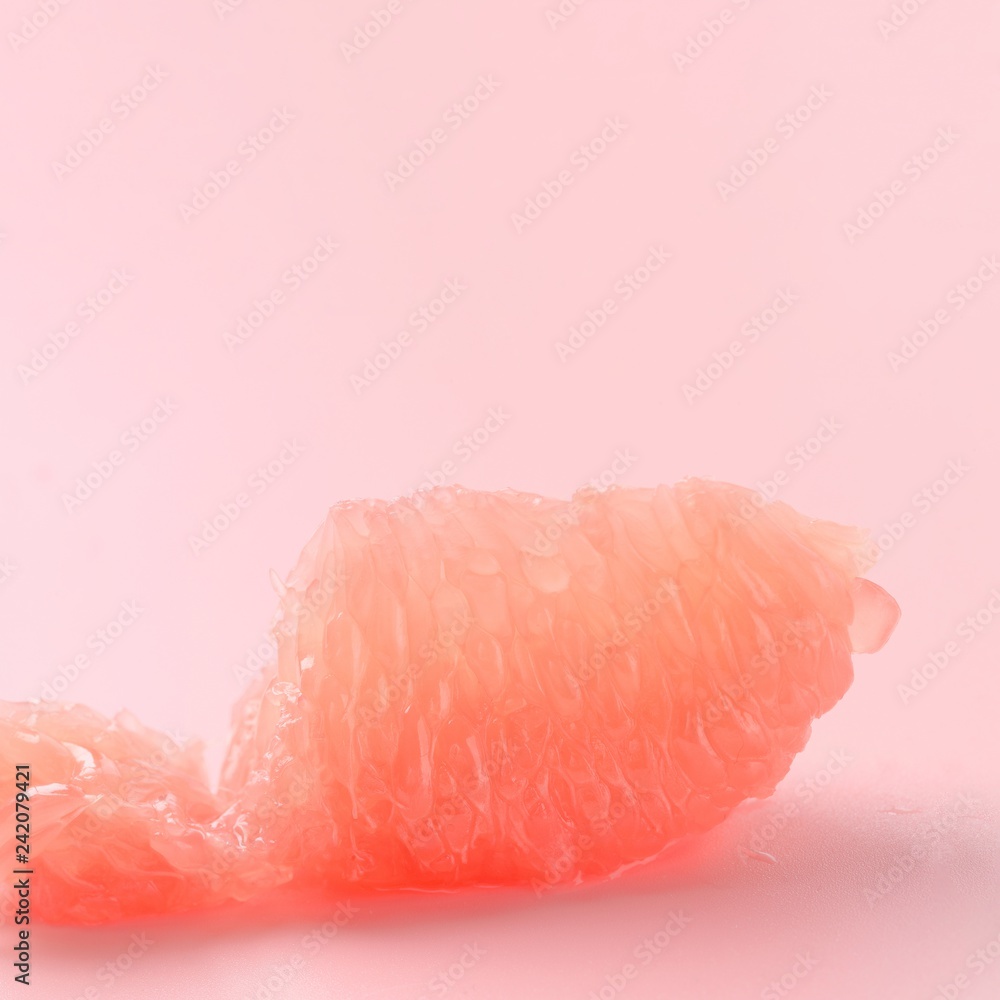 Red Grapefruit piece on pastel pink background. Minimal healthy fresh fruit. Grapefruit succulent pulp. Pantone treendy color of year 2019 Living Coral minimal fashion concept. Copy space for text. Red Grapefruit piece on pastel pink background. Minimal healthy fresh fruit. Grapefruit succulent pulp. Pantone treendy color of year 2019 Living Coral minimal fashion concept. Copy space for text.