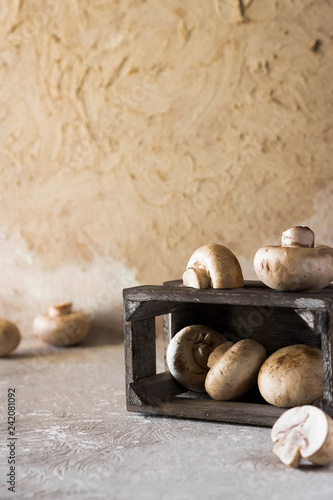 Raw champignons on a rustic wooden box