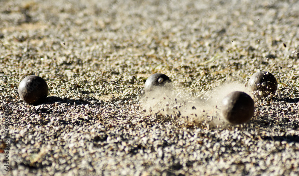 Throwing one petanque ball against another ball and impacting many other balls, until the small pebbles bounce along the impact. Throwing one petanque ball against another ball and impacting many other balls, until the small pebbles bounce along the impact.
