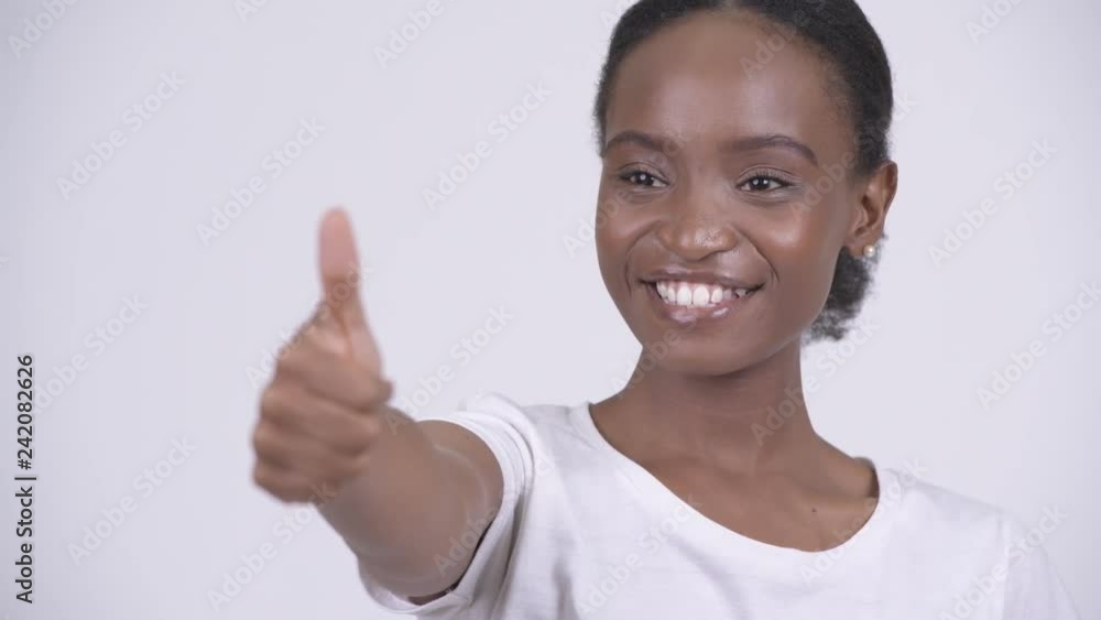Face of young happy African woman smiling and giving thumbs up Face of young happy African woman smiling and giving thumbs up