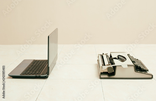 Typewriter and laptop in comparing between low and high business equipment. Concept of technology progress.