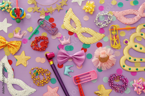 Purim celebration concept (jewish carnival holiday) over pink wooden background. Top view. photo