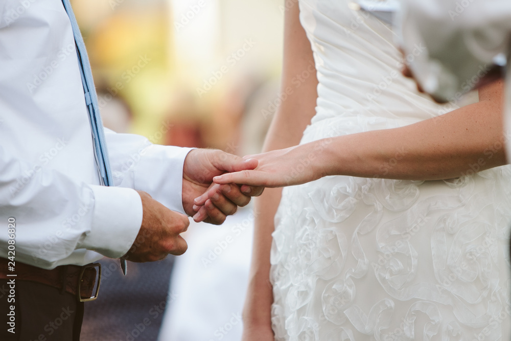 wedding couple holding hands and putting ring on finger wedding couple holding hands and putting ring on finger