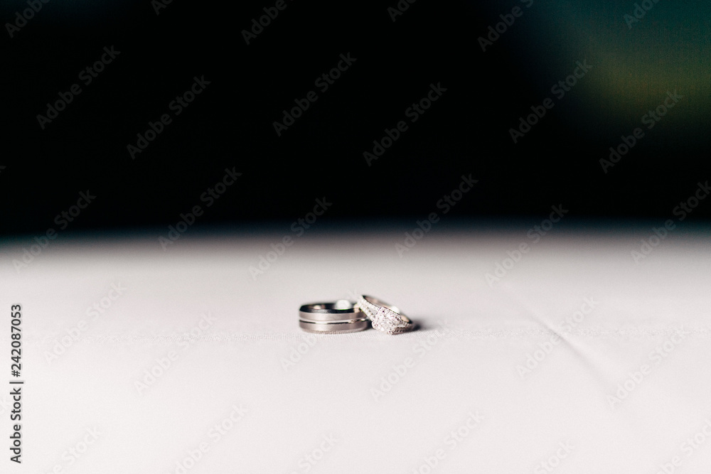 closeup of bride and groom rings on table closeup of bride and groom rings on table