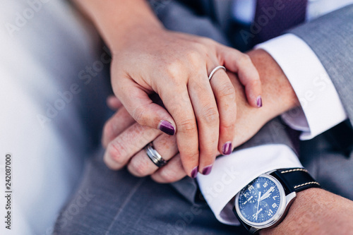 married couple holding hands showing ring and watch
