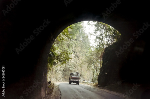 Car drives through the Highway Urban Tunnel. View from badly lit tunnel from a fast moving car on a sunny day. Motion Blur Background.