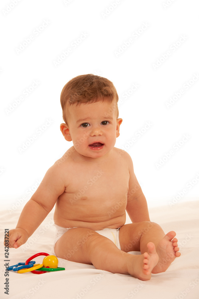 Hapy baby boy in playing on bed isolated over white Hapy baby boy in playing on bed isolated over white