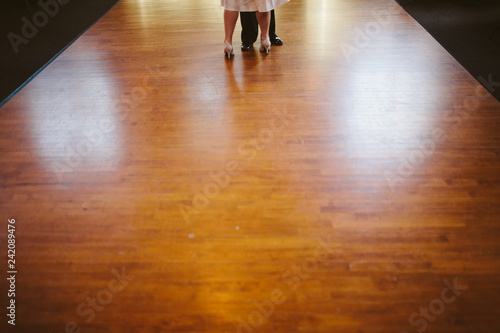 two people dancing on wooden floor