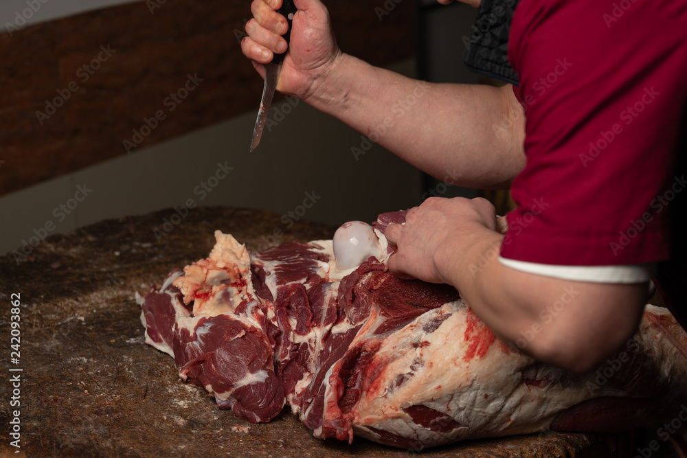 A butcher chopping meat for sale on the market