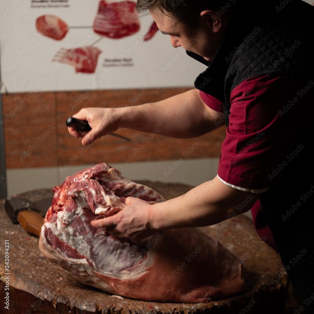 a butcher cuts lamb meat in the market