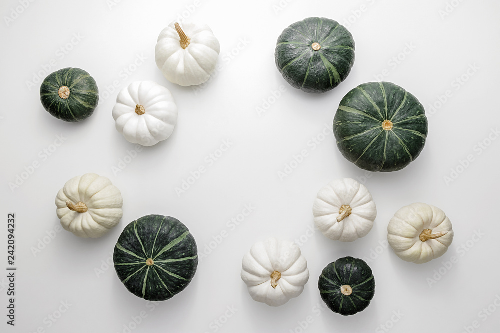White and green pumpkins on a white background, creative flat lay thanksgiving concept, top view with copy space White and green pumpkins on a white background, creative flat lay thanksgiving concept, top view with copy space