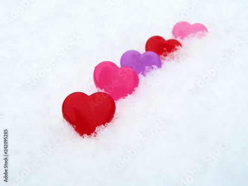 Valentine hearts in the snow, symbols of love. Background for romantic greeting card with free copy space