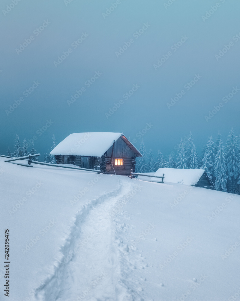Fantastic winter landscape with wooden house in snowy mountains. Christmas holiday concept. Carpathians mountain, Ukraine, Europe