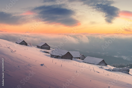 Fantastic winter landscape with wooden house in snowy mountains. Christmas holiday concept. Carpathians mountain, Ukraine, Europe