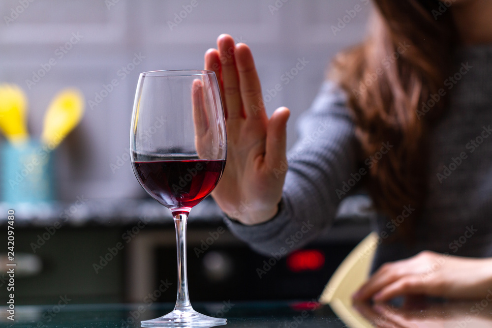 Woman refuses to drink a alcohol. Female alcoholism concept. Treatment of alcohol addiction. Quit booze and alcoholism. Woman refuses to drink a alcohol. Female alcoholism concept. Treatment of alcohol addiction. Quit booze and alcoholism.
