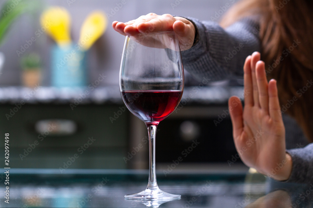 Woman refuses to drink a alcohol. Female alcoholism concept. Treatment of alcohol addiction. Quit booze and alcoholism. Woman refuses to drink a alcohol. Female alcoholism concept. Treatment of alcohol addiction. Quit booze and alcoholism.