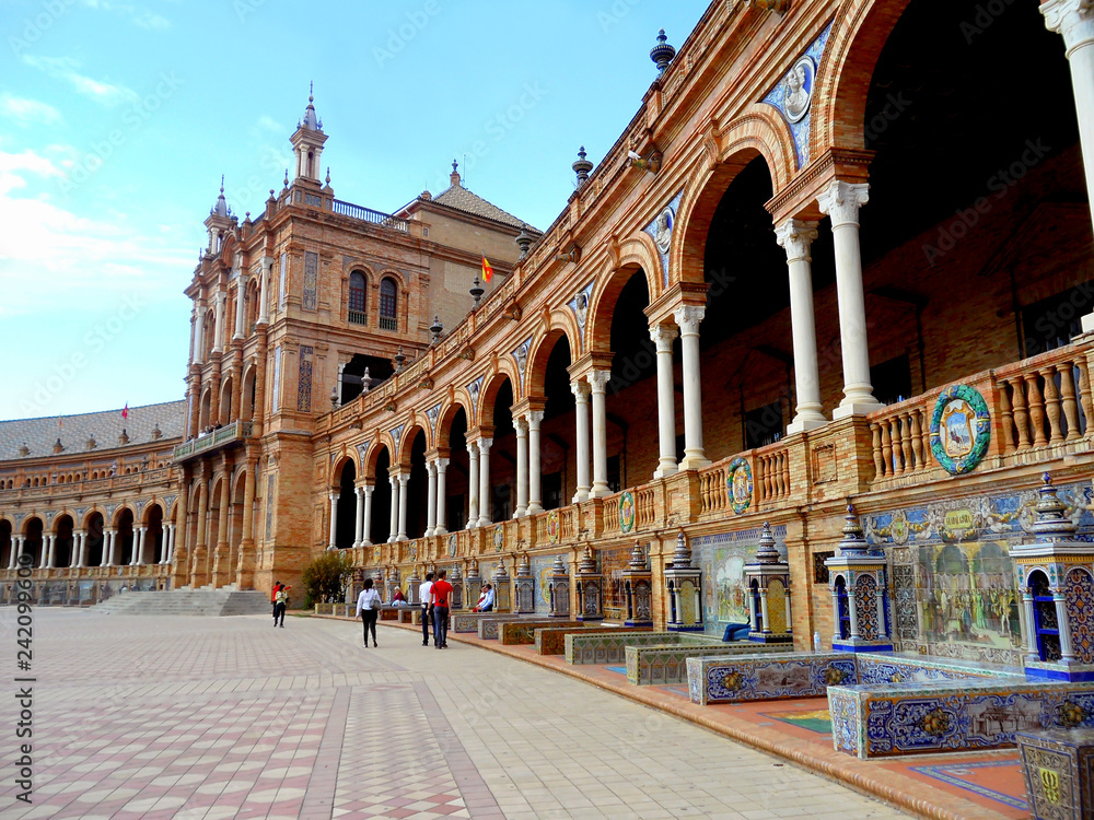 The series of benches at the facade of main structure of Plaza de Espana square decorated with impressive Azulejos or painted ceramic tiles, Seville, Spain 