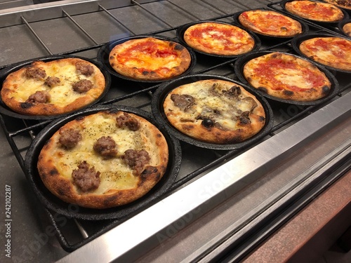 Various cooked traditional italian pizzas in oven