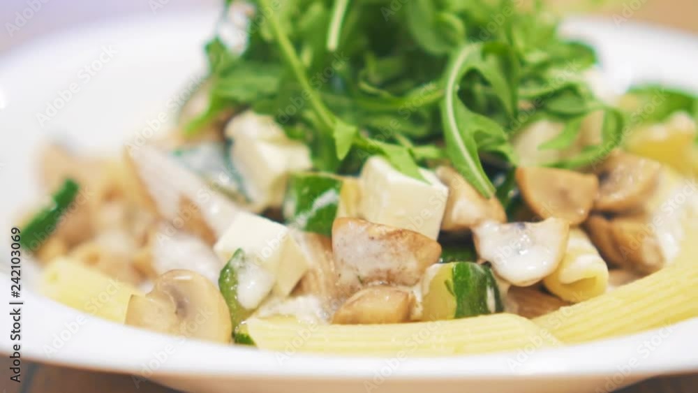 Rotating plate with chicken, zucchini, champignons and pasta. Rotating plate with chicken, zucchini, champignons and pasta.