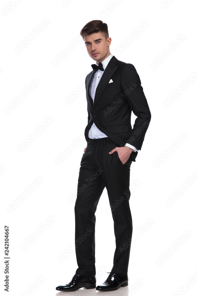 classy man in black tuxedo standing with hands in pockets classy man in black tuxedo standing with hands in pockets