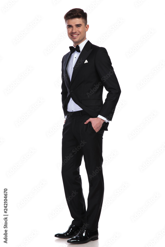 joyful relaxed groom standing with hands in pockets and smiling joyful relaxed groom standing with hands in pockets and smiling