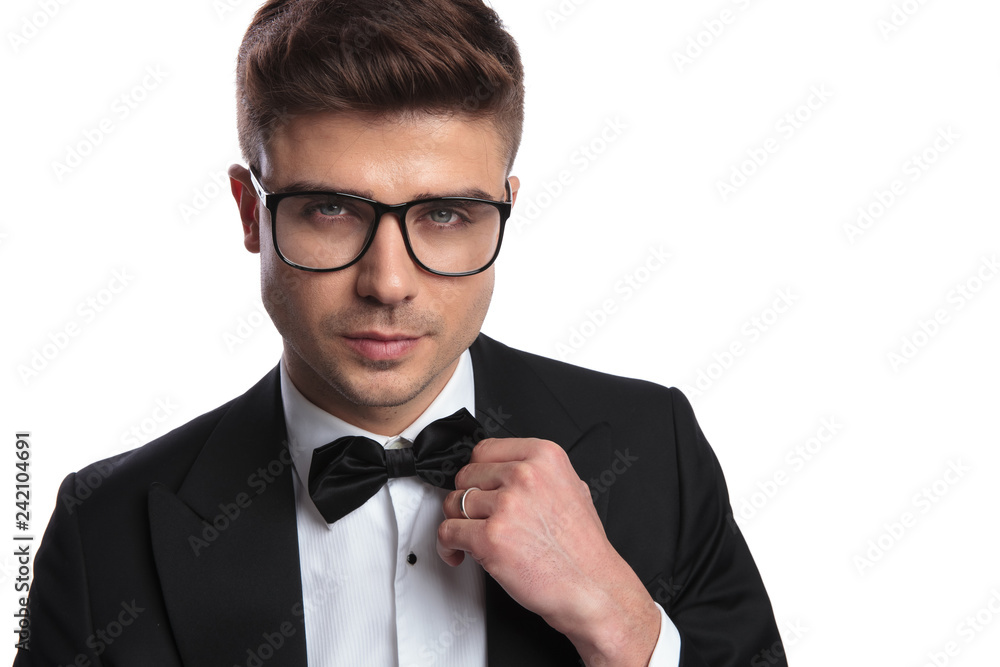 portrait of young businessman with sunglasses arranging his bowtie portrait of young businessman with sunglasses arranging his bowtie