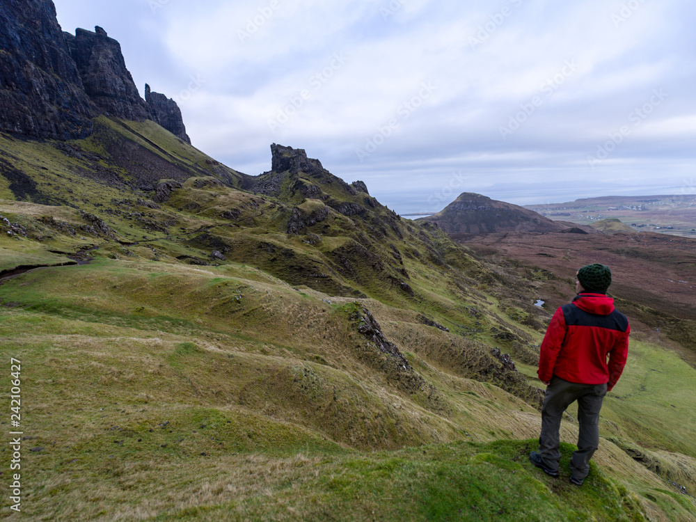Single hiker on top of mountain in rugged volcanic landscape around Old Man of Storr, Isle of Skye, Scotland
