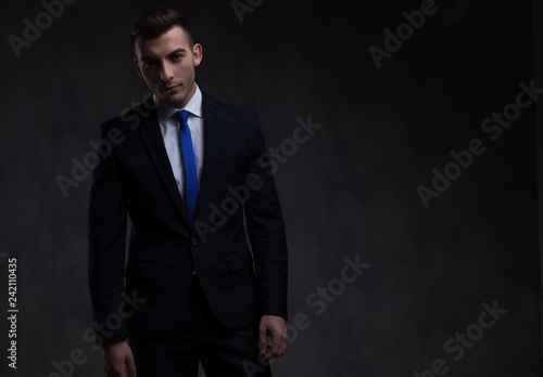 portrait of handsome smart casual man in navy suit standing