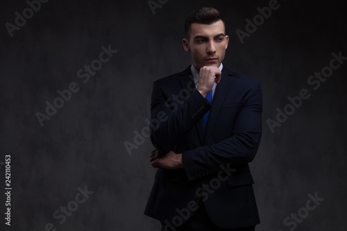 portrait of pensive businessman in navy suit looking to side