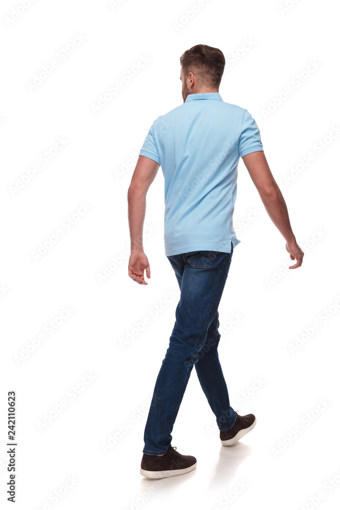 young man in polo shirt walks and looks to side young man in polo shirt walks and looks to side