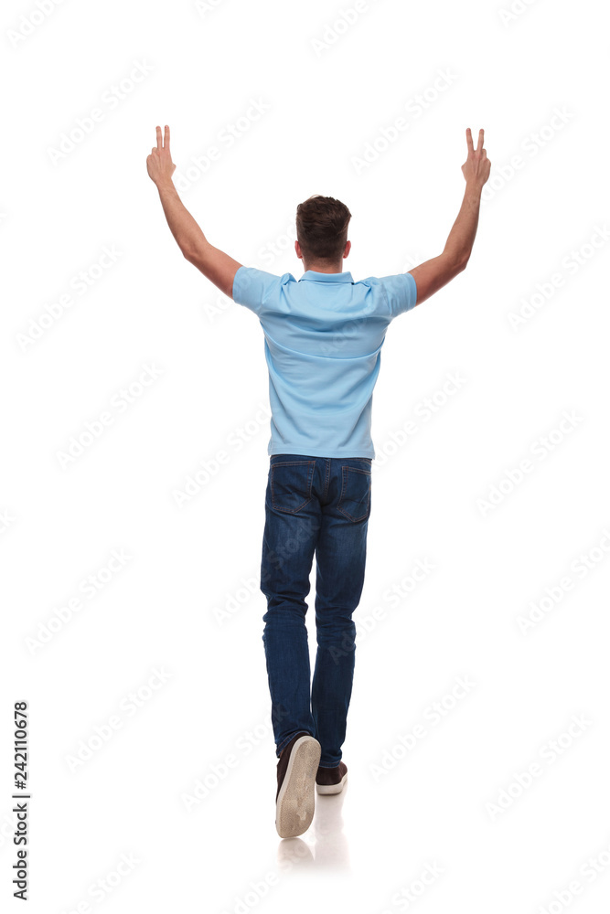 back view of casual man celebrating and making peace sign back view of casual man celebrating and making peace sign