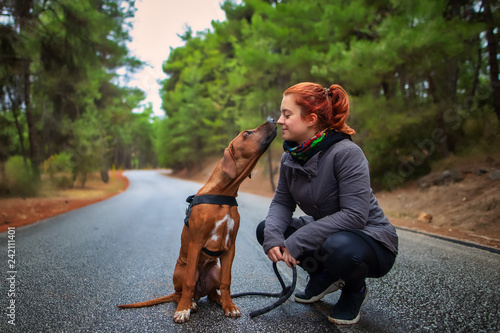 Portrait of happy teenage girl and Rhodesian ridgeback dog . Dog giving girl sweet kiss lick. Love animals love my pet