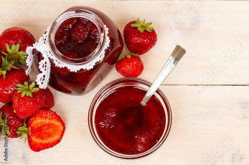 Fresh homemade strawberry jam with berries in small jars, top view