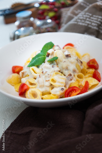 Cooked pasta with a cream sauce and roasted chicken cured with emmental.
