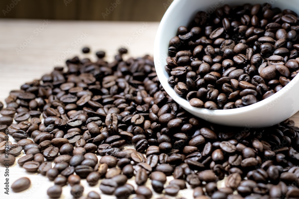 Fototapeta premium Coffee beans are placed in containers and spread on the background of wood grain.