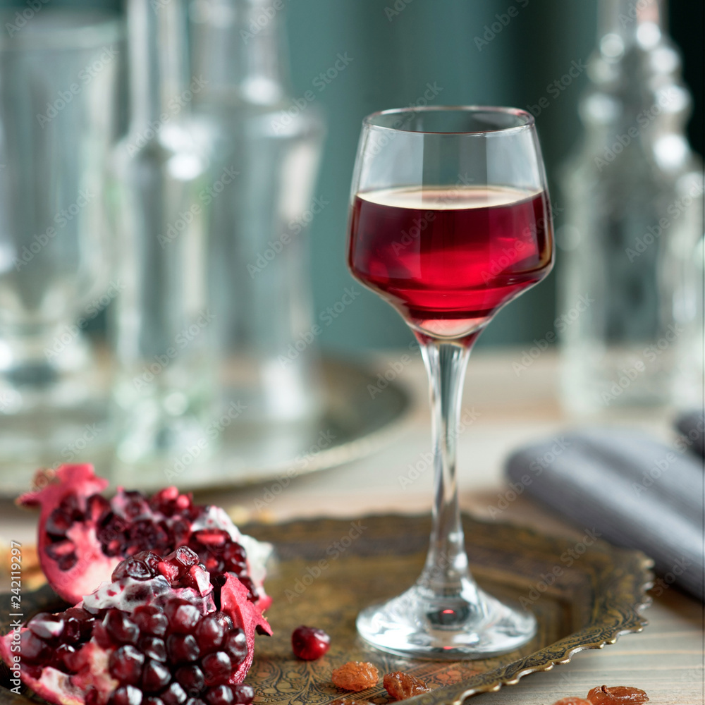 A glass of pomegranate liqueur on the table with grenades A glass of pomegranate liqueur on the table with grenades