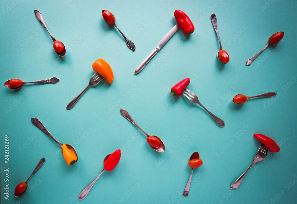 Blue background with old forks and spoons and peppers Blue background with old forks and spoons and peppers