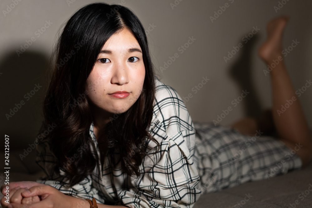 Beautiful Young Japanese Girl Lying on a Couch Stock Photo