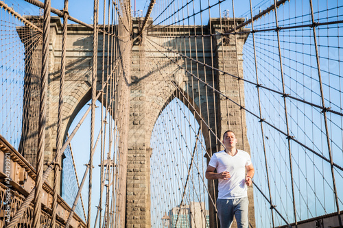 Young athlete jogging on Brooklyn Bridge in New York City © Stefan