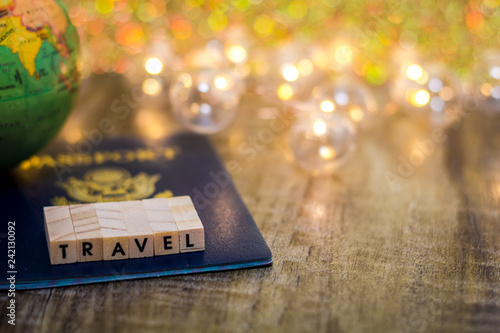 Travel still life concept with passport and fun lights on wooden board, shallow DOF