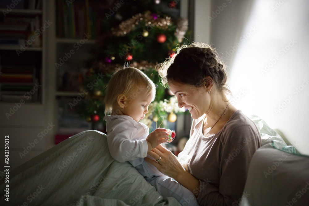 Young beautiful mother, breastfeeding her newborn baby boy at night, dim light. Mom breastfeeding toddler Young beautiful mother, breastfeeding her newborn baby boy at night, dim light. Mom breastfeeding toddler