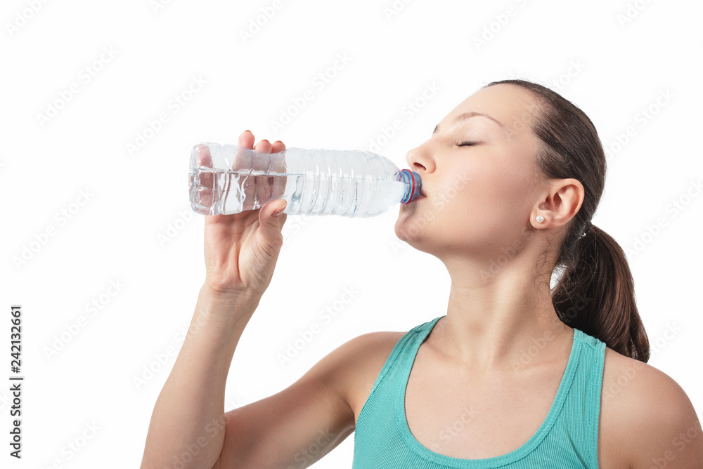 Young beautiful woman drinks water from a bottle. Young beautiful woman drinks water from a bottle.