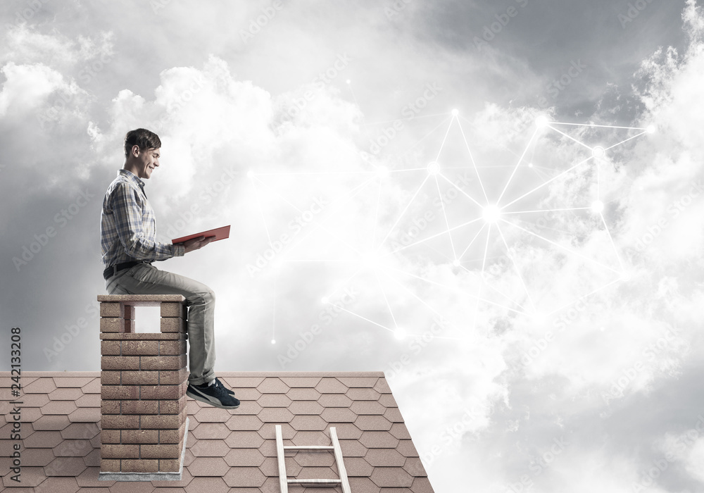 Man on brick roof reading book and concept of social connection Man on brick roof reading book and concept of social connection