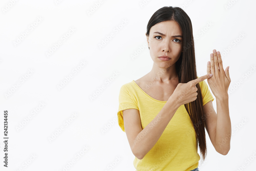 Two years passed when proposal happen. Portrait of displeased irritated serious-looking girlfriend frowning staring strict at camera raising palm and pointing at ring finger hinting on marriage Two years passed when proposal happen. Portrait of displeased irritated serious-looking girlfriend frowning staring strict at camera raising palm and pointing at ring finger hinting on marriage