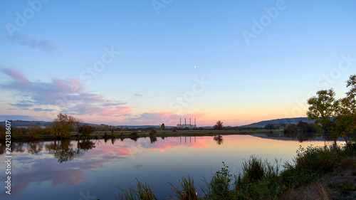 Fototapeta Naklejka Na Ścianę i Meble -  Panoramic View Of A Lake At Sunset With A Coal Power Station In