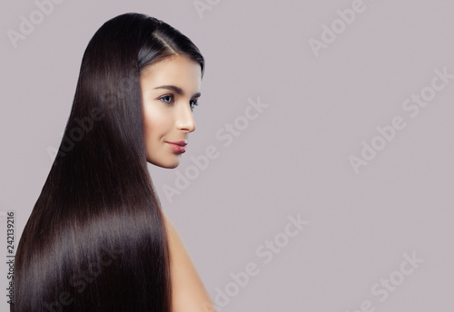 Elegant woman with straight healthy hair and clear skin on pink