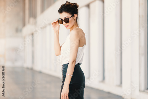 Refined business woman holding fashionable sunglasses down looki © arthurhidden