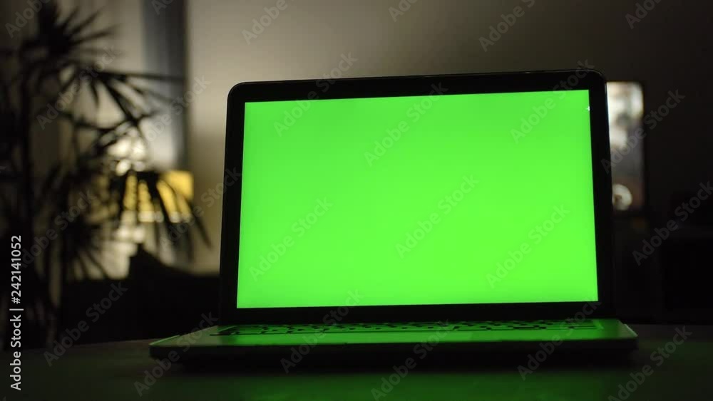Laptop with green screen. Dark home office . Dolly shot of Perfect to put your own image or video. Laptop with green screen. Dark home office . Dolly shot of Perfect to put your own image or video.