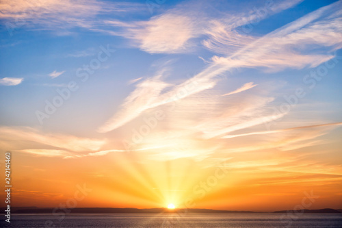 Sunrise with Sun, Sun Rays, Blue Sky, Clouds and Sea